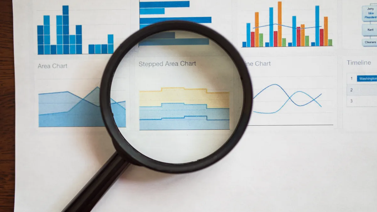 Rank Tracker Features to Look for Before You Buy — A Magnifying Glass on a Page of Various Charts